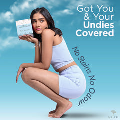 AZAH model in light blue activewear holding box of organic cotton panty liners on blue background