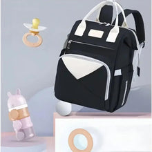Black baby backpack with white top handles, front zip pocket and insulated panel