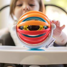 Baby Einstein sticky spinner toy with orange and red loops and white suction base on tray