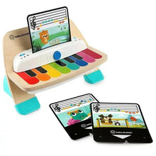 Wooden music toy piano with rainbow keys and two tablet cards resting nearby
