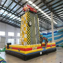 Inflatable rock climbing play structure with tall checkered climbing tower and arched entrance