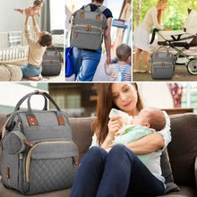 Gray diaper travel backpack worn on back with front organizer compartments