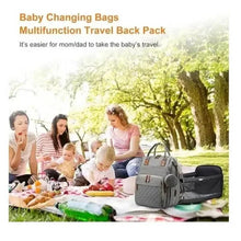 Gray diaper travel backpack near a picnic blanket, with parents and baby in scene