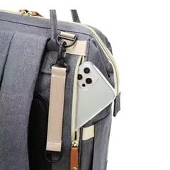 Huitich baby travel backpack diaper bag in gray with side pocket holding a smartphone