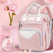 Pink baby travel backpack with white front panel, three handles, and zip pocket