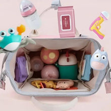 Pink baby travel backpack open to show spacious interior with baby items
