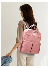 Pink baby travel backpack, side view with adjustable shoulder straps and front pocket