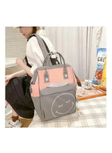 Grey and pink baby travel bag worn on a person with front gray face patch