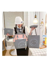 Grey and pink baby travel bag set worn on a person: tote and backpack with face patch
