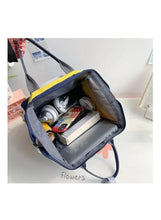 Open grey baby travel bag with mesh inner pockets and visible baby supplies
