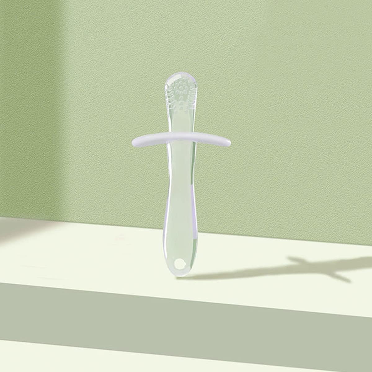 Translucent green silicone baby teething stick with textured tip and safety guard for infants