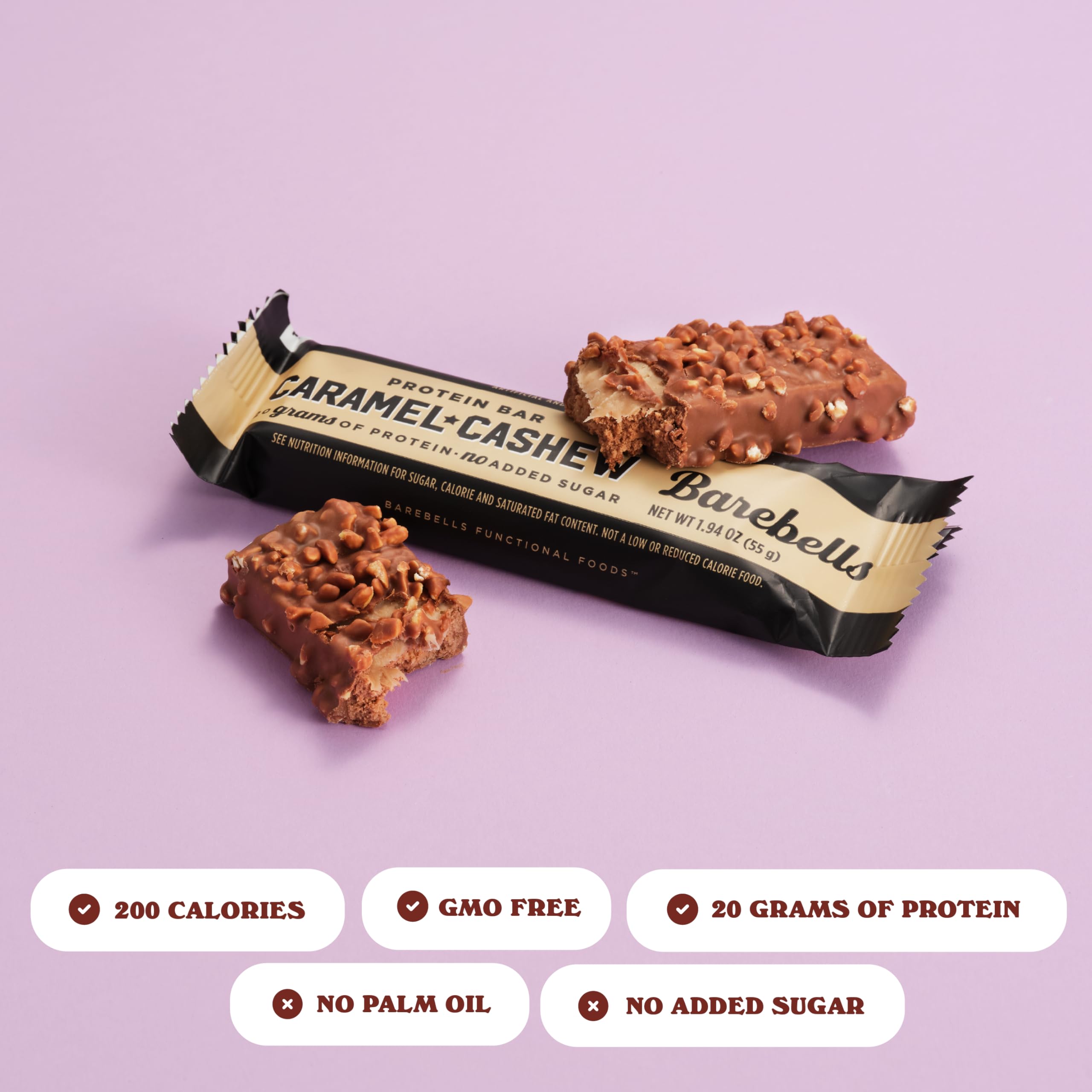 Barebells protein bars caramel cashew chocolate coated bar with caramel and cashew pieces split next to wrapper on pink background