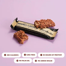 Caramel cashew protein bars with nutty chocolate pieces, showing black wrappers