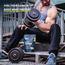 Whey protein pouch on the ground near a workout bench and dumbbells