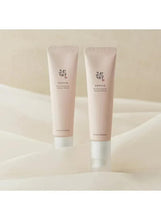 Two light beige eye serum tubes standing side by side