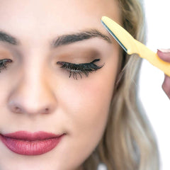 Close up of woman shaping brows with a yellow eyebrow razor for women and men for precise trimming
