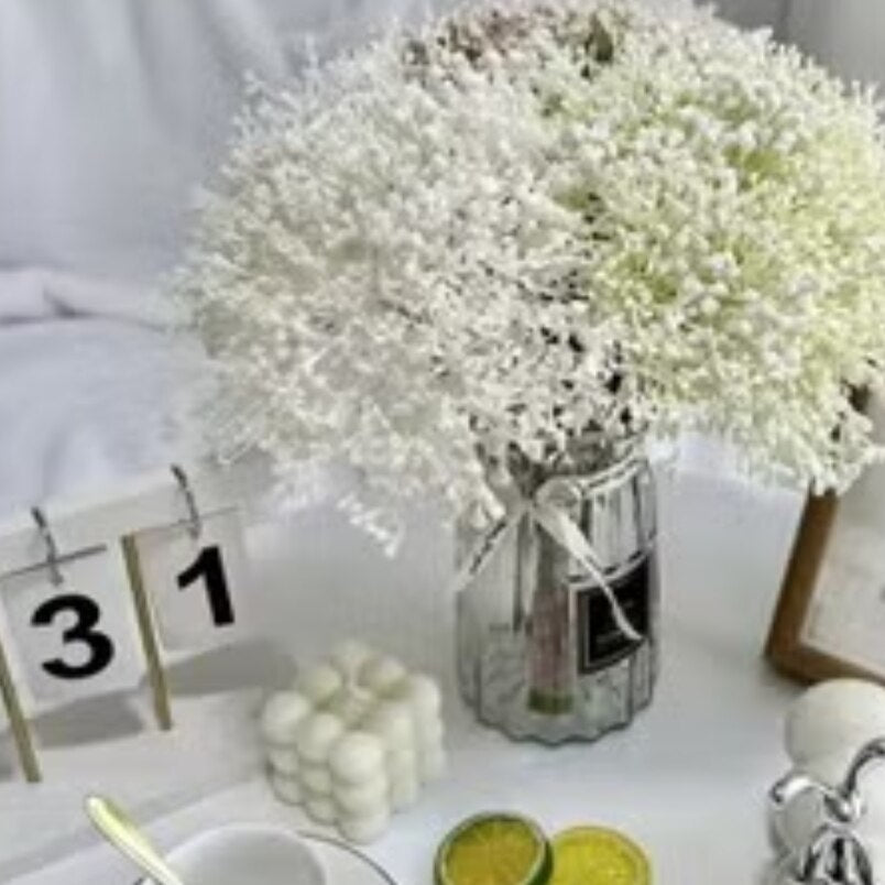 Huitich beige artificial flower decor in clear glass vase on white table with calendar and citrus slices