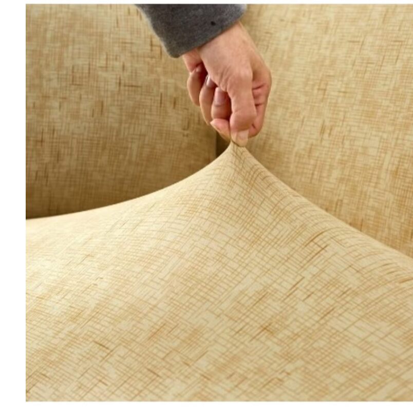 Hand pulling beige elastic sofa cover made by Huitich showing its stretch and fit on sofa