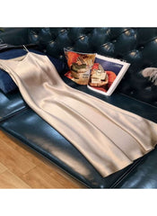 Huitich beige sleeveless satin dress XL laid out on a dark leather couch showcasing its smooth fabric and elegant design