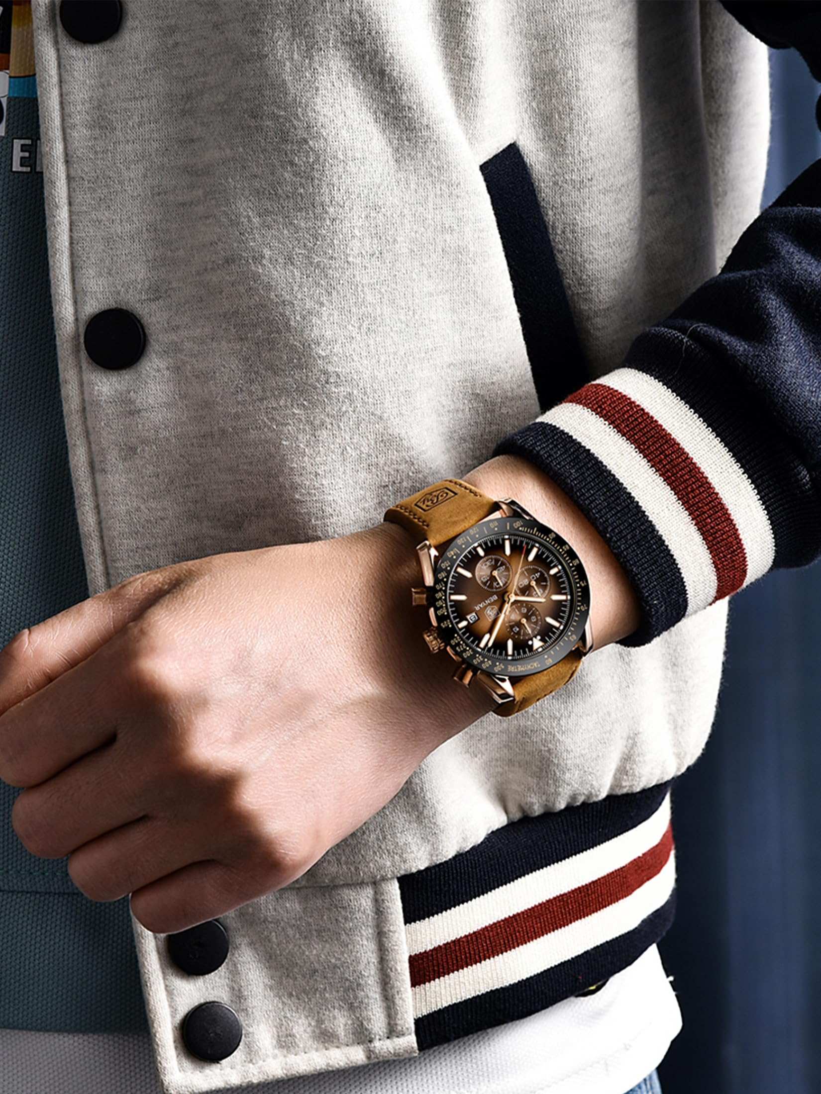 business casual analog watch for men with brown leather strap worn on wrist with varsity jacket