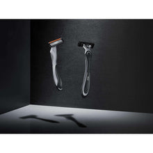 Disposable razors with silver heads and black grips, shown side by side