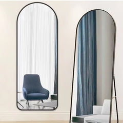 Huitich black aluminum frame mirror with an arched top, reflecting modern room interiors with curtains and furniture