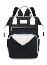 Baby travel backpack with top handles, front zip pocket, and white contrast panel