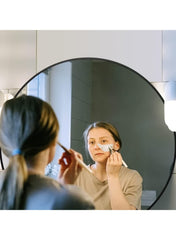 Huitich black round wall mirror with lights mounted on bathroom wall with woman applying makeup