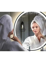 Round black wall mirror with illuminated edge and bathroom reflection