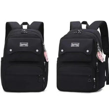 Black school backpack front view with two zip compartments, top handle, and side keychain.