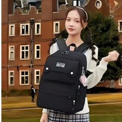 Black school backpack for girls by Huitich worn by girl outdoors near brick building