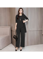 Elegant black three-piece slim suit for women styled with black heels and a matching handbag