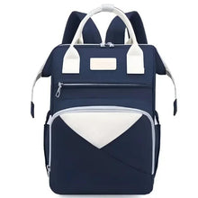 Navy baby backpack with white trim, top handle, front zip pocket, side storage