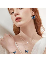Butterfly jewelry set on model: blue butterfly earrings and pendant necklaces