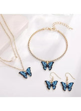 Butterfly jewelry set flat lay: blue butterfly pendants, gold-tone chain bracelet and earrings
