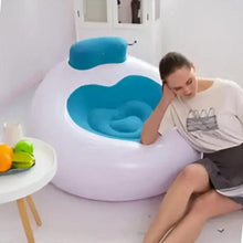 Inflatable lounge chair with teal backrest and blue seat, person sitting indoors