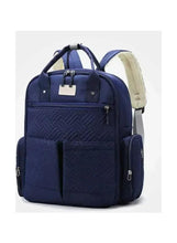 Blue quilted travel backpack with front pockets and top handle, light beige side panel