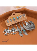 Boho turquoise earring set with leaf, tree, and heart-shaped charms on silver hooks