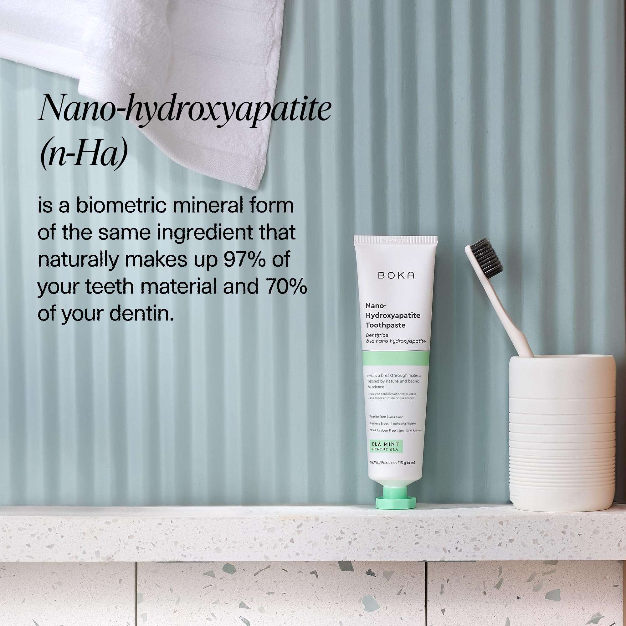 Boka nano hydroxyapatite toothpaste tube on bathroom counter with toothbrush and cup fluoride free toothpaste for sensitive teeth