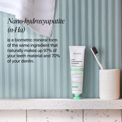 Boka nano hydroxyapatite toothpaste tube on bathroom counter with toothbrush and cup fluoride free toothpaste for sensitive teeth
