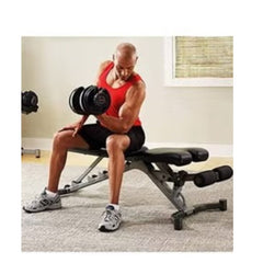 Man lifting 24kg adjustable dumbbell set by Huitich while seated on workout bench at home gym