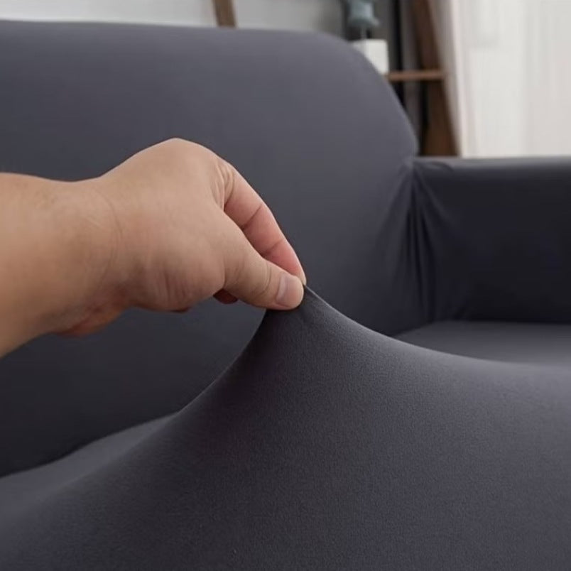 Huitich elastic sofa slipcover for 2 seater in dark gray being stretched by hand to show elasticity