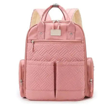 Pink quilted diaper backpack with front organizer pockets and top handle