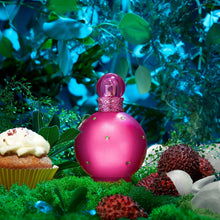 Pink perfume bottle with faceted cap among cupcakes and berries