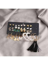 Earring set featuring green butterfly studs, pearl hoops, and black tassel dangles