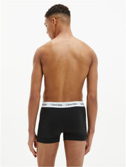 Back view of male model wearing black cotton boxer briefs 3 pack from Calvin Klein with white logo waistband