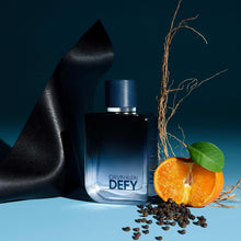 Men body spray bottle with dark cap beside orange fruit, pepper, and leather