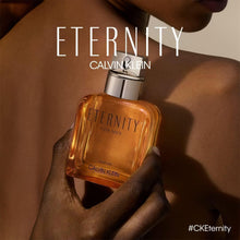 Eternity for Men parfum bottle held in a hand, silver cap, amber glass