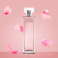 Calvin Klein Eternity Moment perfume bottle with pink liquid surrounded by floating pink rose petals