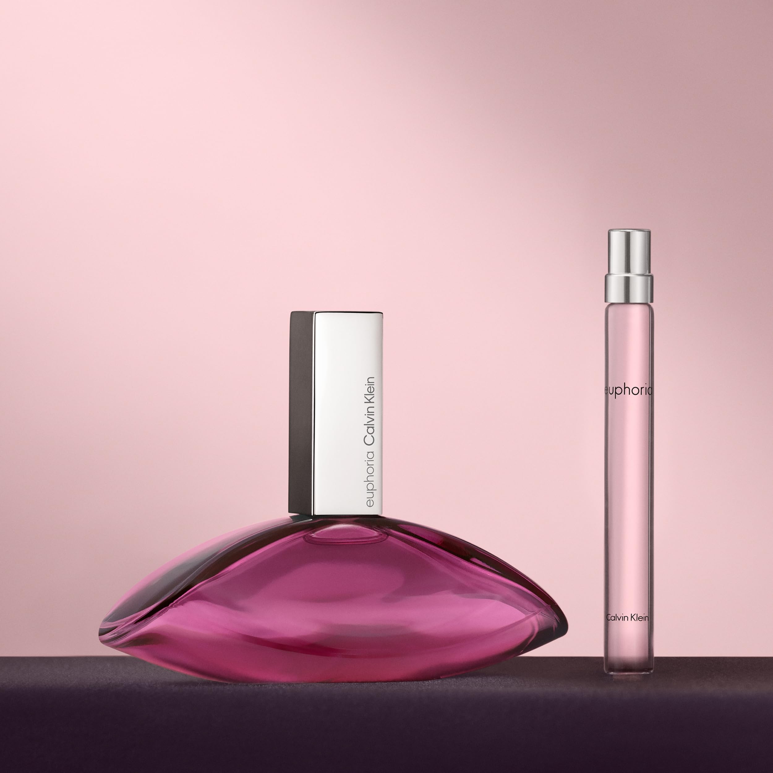 Calvin Klein Euphoria perfume 30ml bottle and travel spray with a chic pink backdrop